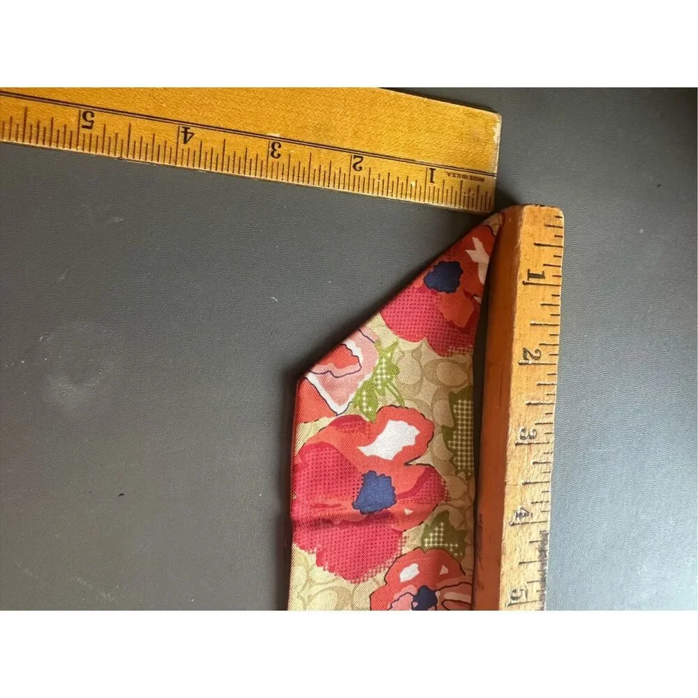 COACH silk twilly scarf orange poppy and tan signature Cs background